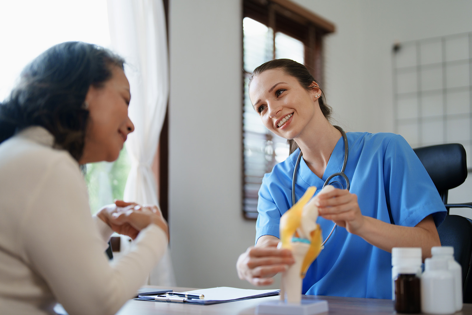 Portrait of a female doctor talking to an elderly patient about osteoarthritis